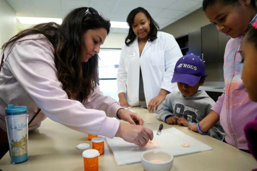 Parent Tina Hitchcock fills a tablet with crushed up Tums in the Pharmacy Tech program at an...