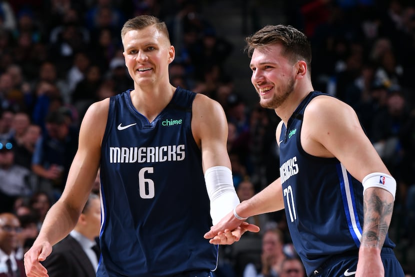 Kristaps Porzingis #6 and Luka Doncic #77 of the Dallas Mavericks high five each other...