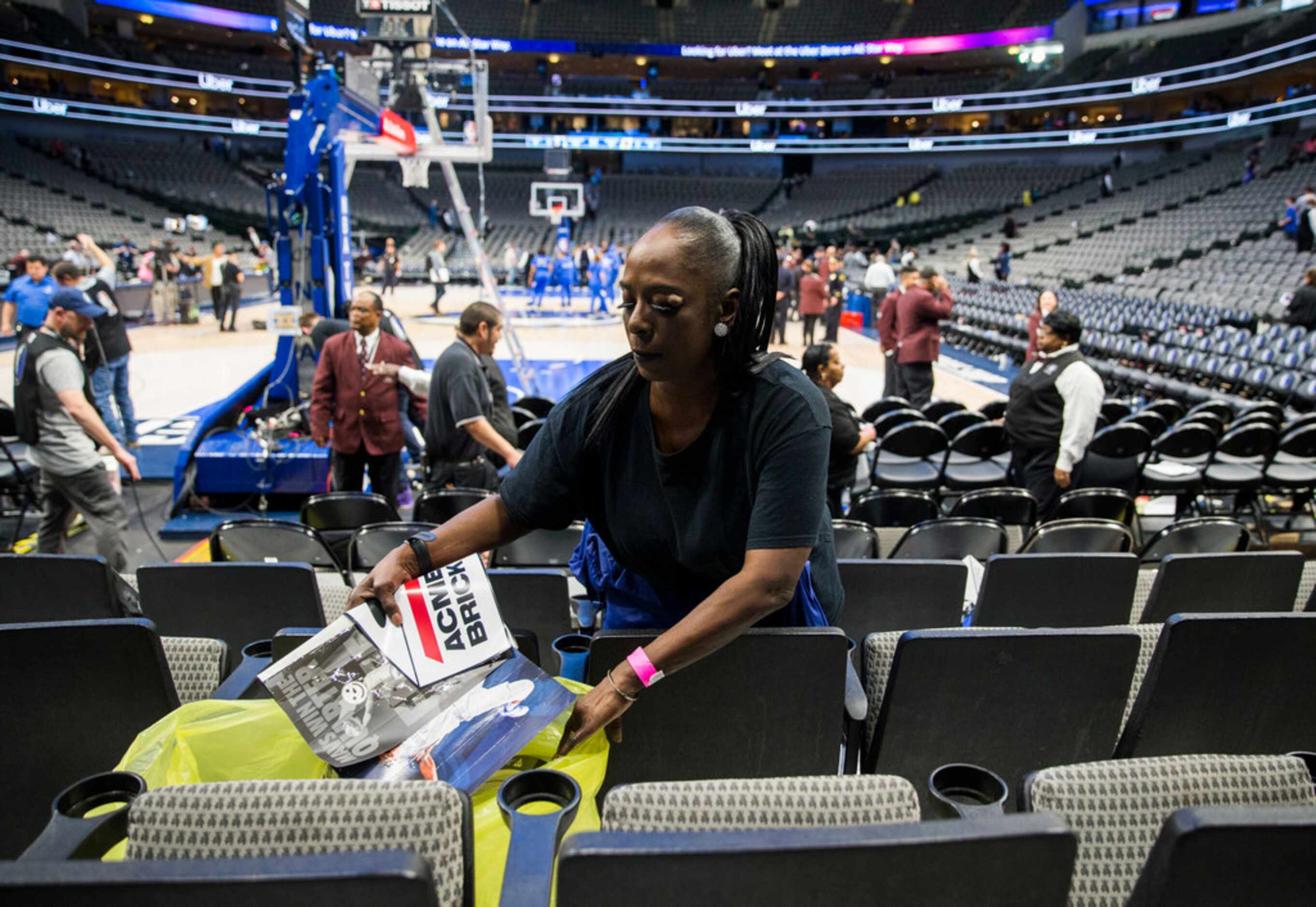 Brenda Brown picks up trash left by fans after the Dallas Mavericks beat the Denver Nuggets...