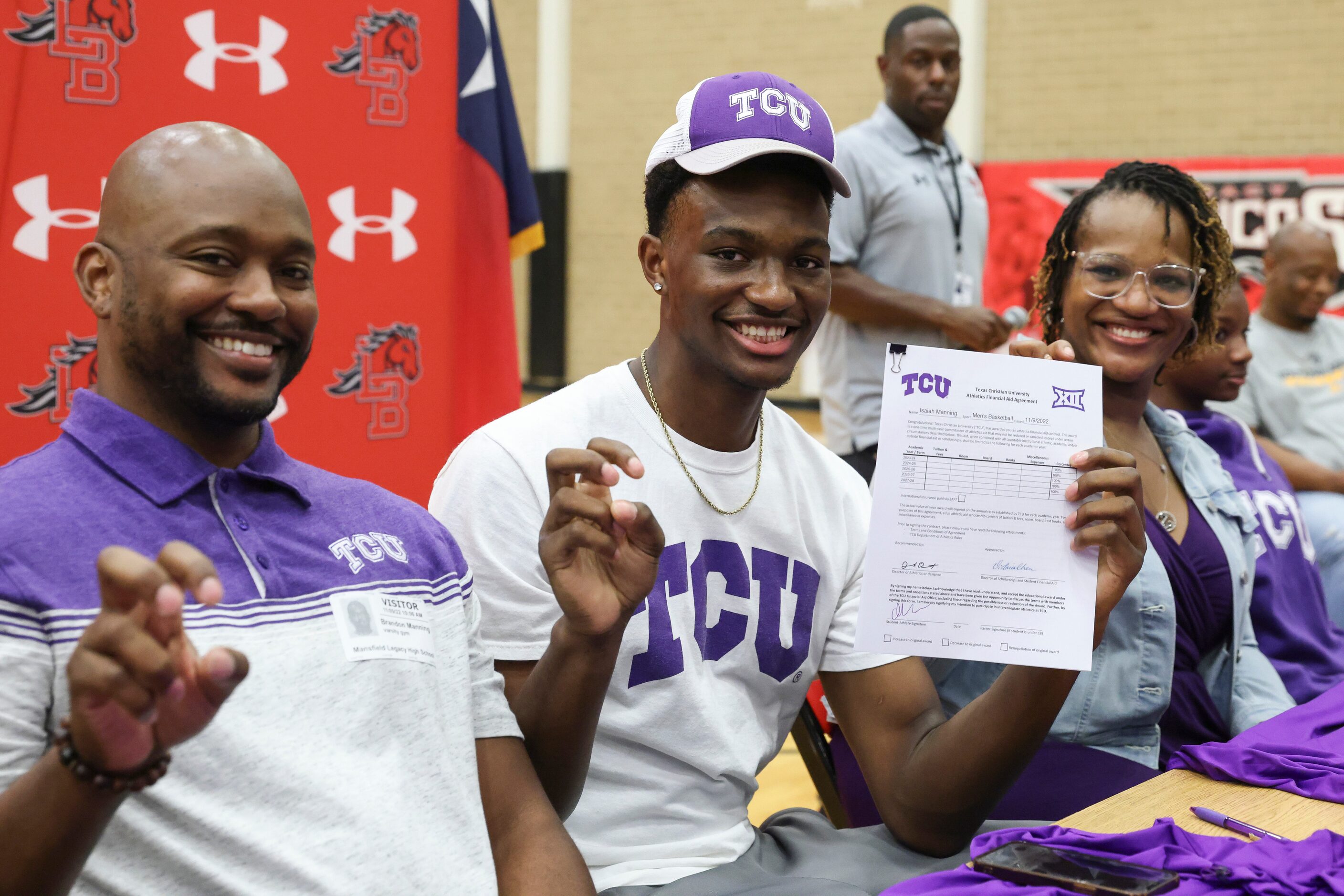 Isaiah Manning sits between his father Brandon and mother Johnnjalyn and holds up a horned...