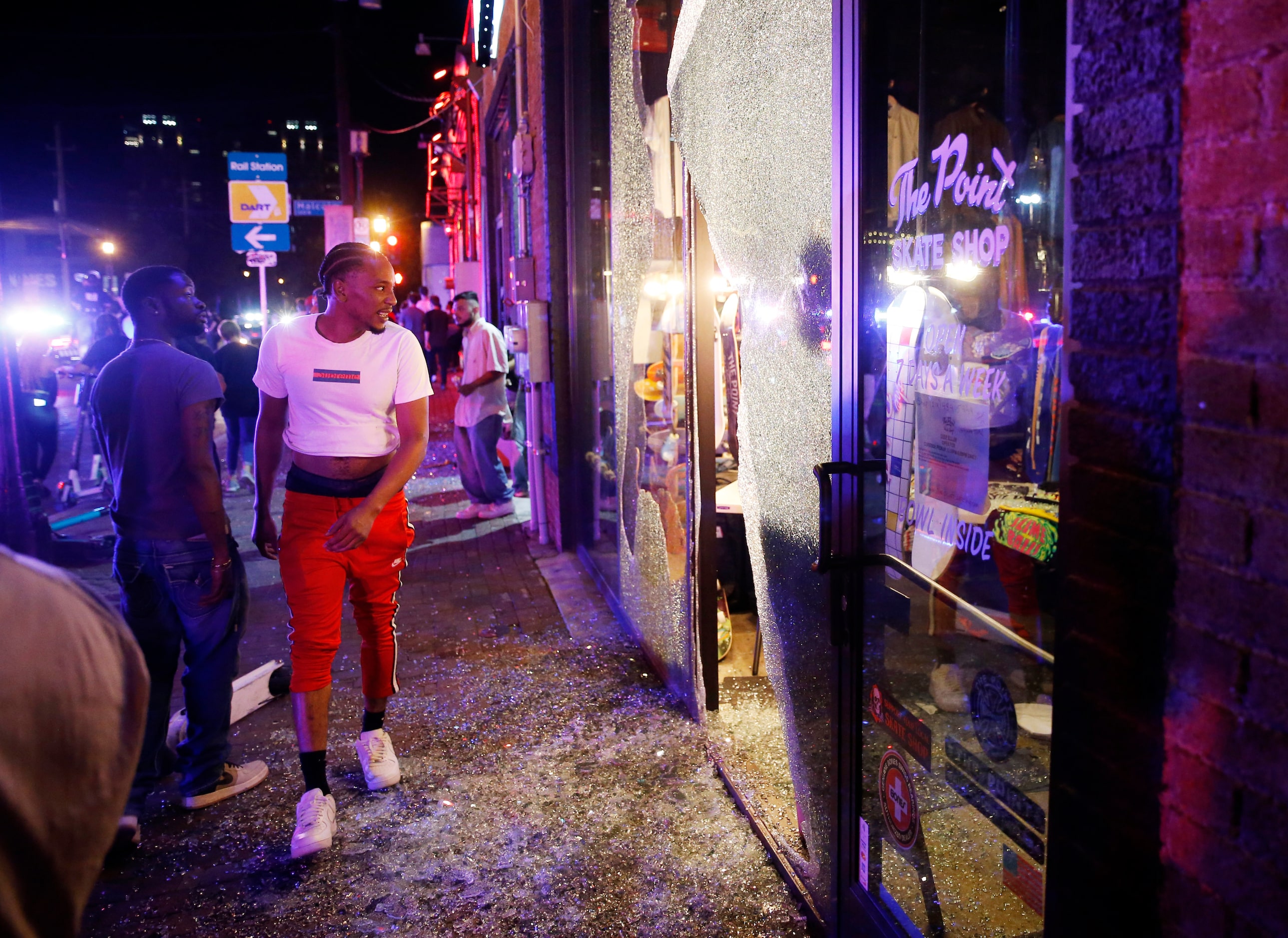 People look inside of the busted window of The Point Skate Shop along Main Street in Deep...