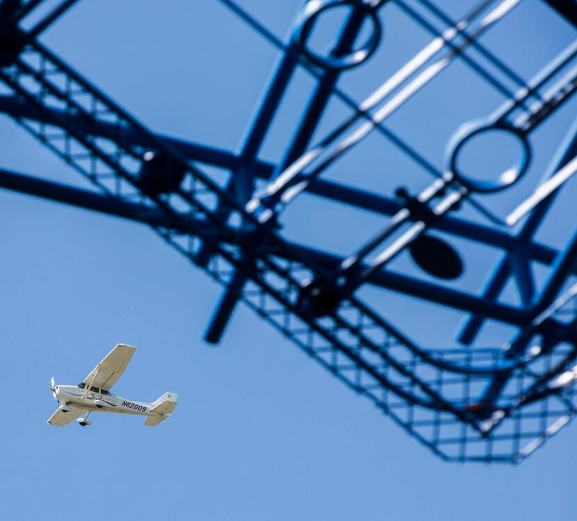 
A plane flies past "Blueprints," a large outdoor sculpture designed by Texas-born artist...