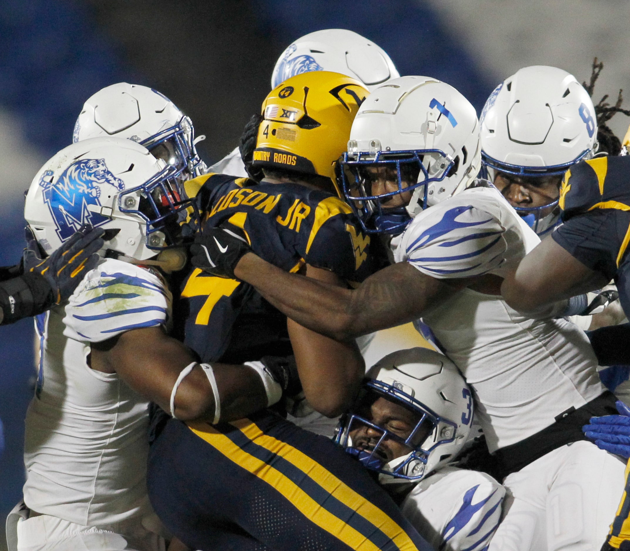 West Virginia running back CJ Donaldson Jr. (4), center, is stopped by a host of Memphis...