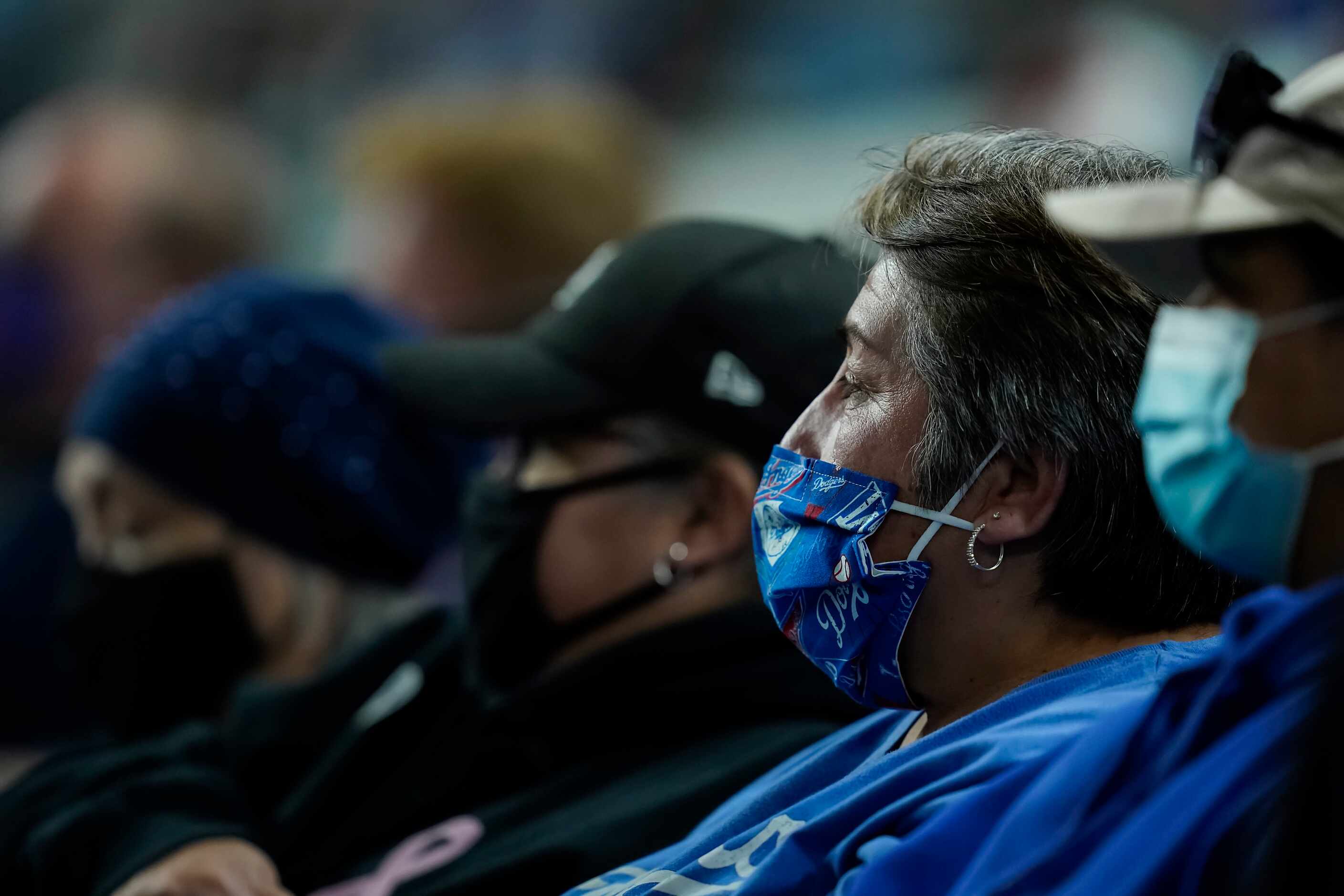 Los Angeles Dodgers fans wear face covering as they watch during the seventh inning against...