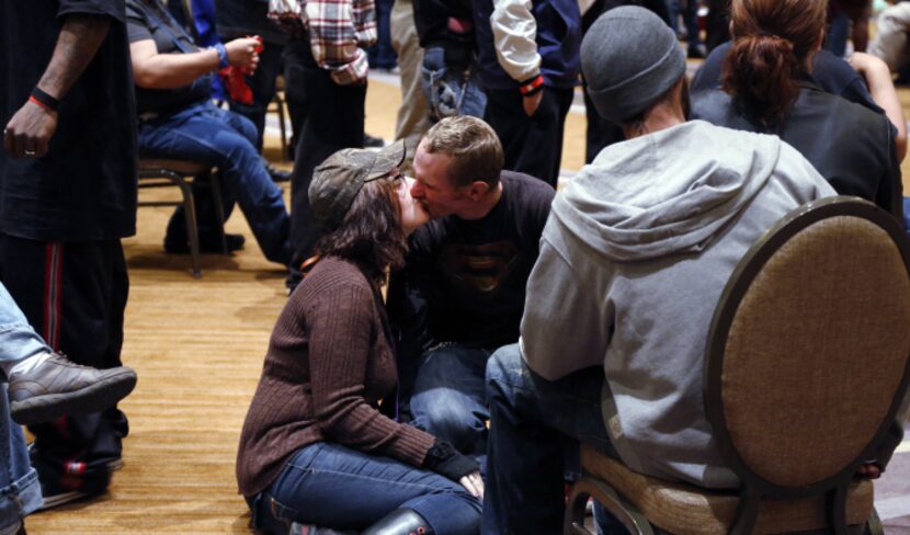 Alice Cowden kisses Shane Goodmon as they wait with other homeless people to have lunch at...