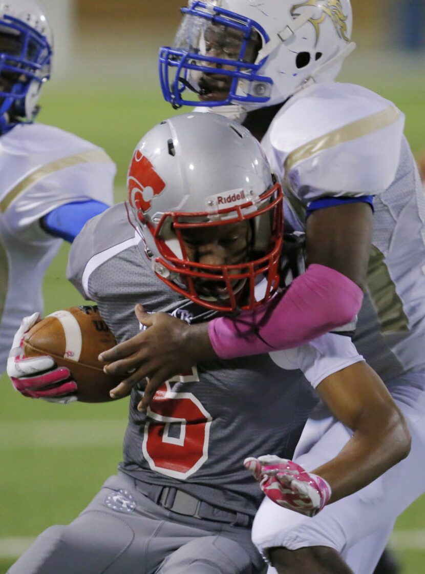 TXHSFB Conrad junior linebacker Denzel Thompson, right, tackles Woodrow Wilson senior wide...