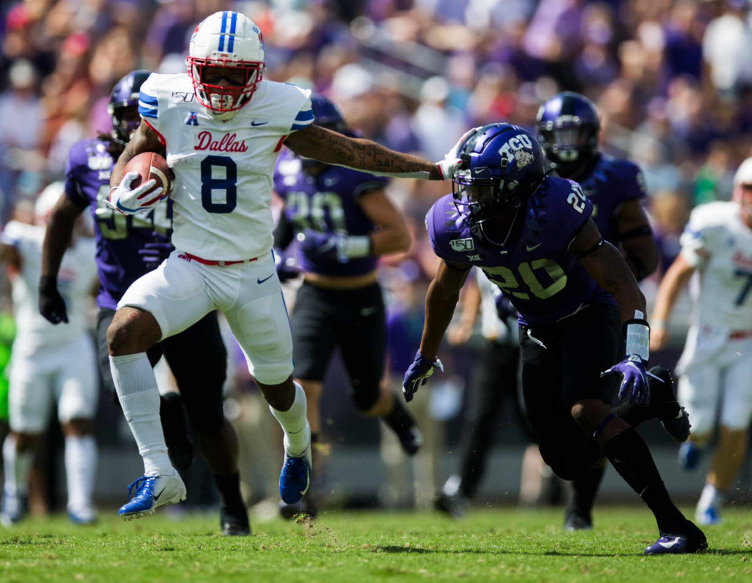 Southern Methodist Mustangs wide receiver Reggie Roberson Jr. (8) stiff arms TCU Horned...