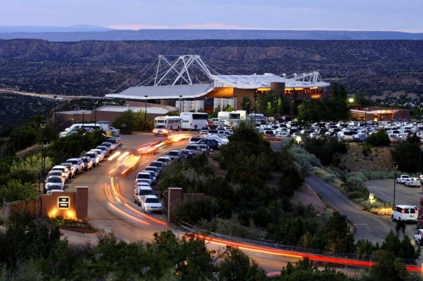 A line of cars heads toward the open-air Santa Fe Opera house, located in the foothills...