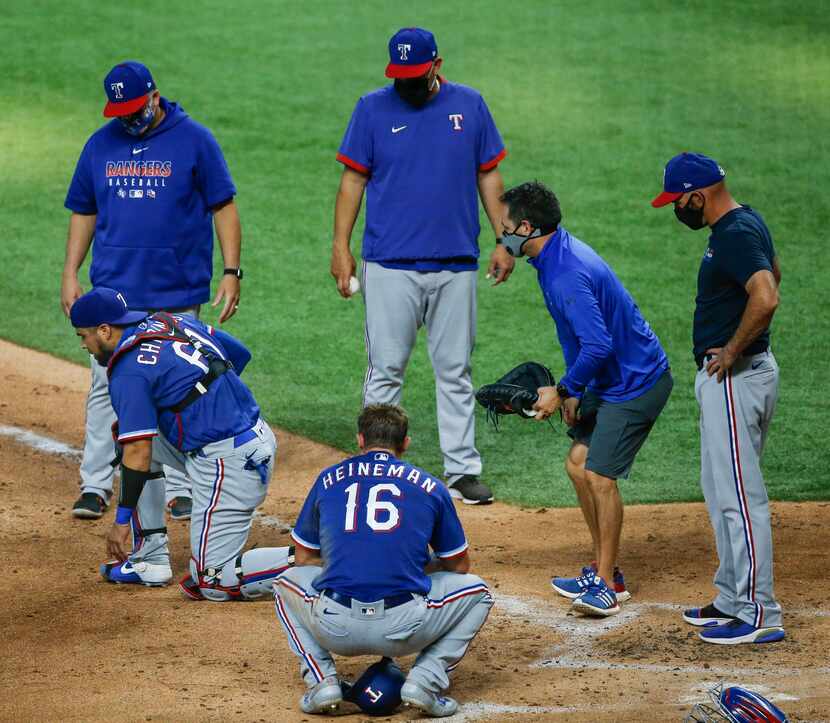 Catcher Robinson Chirinos works to stand up after being injured during a run-in at home...