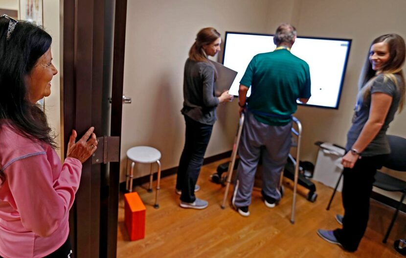 Betty Bachtel  (left) watches her husband, Mark Bachtel, during a session with occupational...