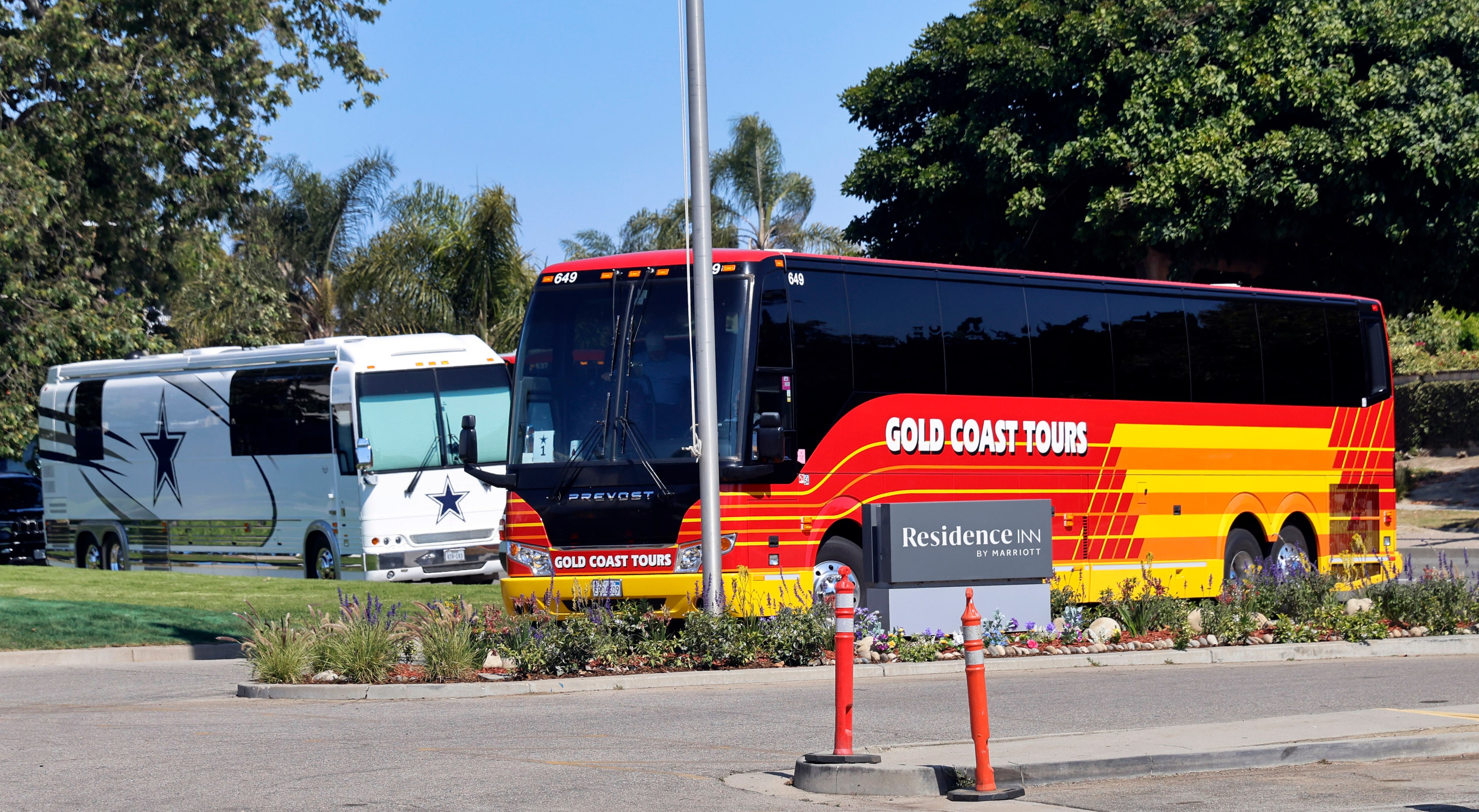 Dallas Cowboys players, coaches and staff arrive on charter buses at the Residence Inn...