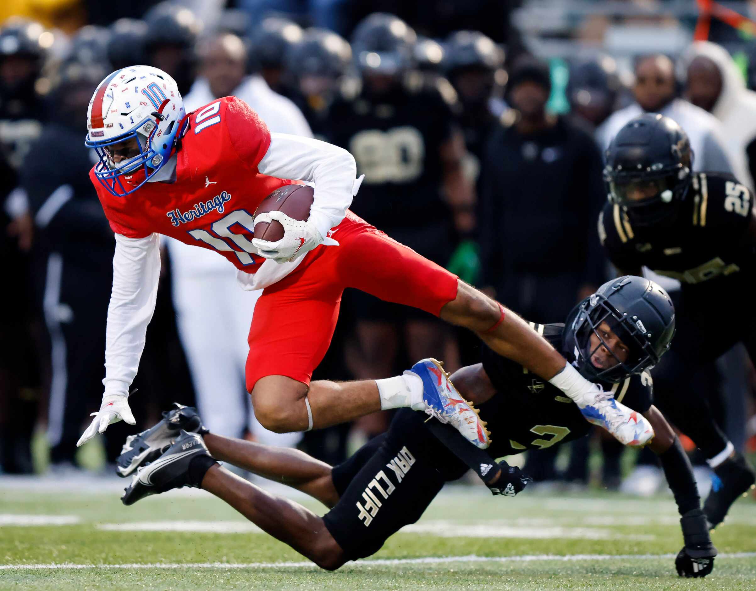 Midlothian Heritage wide receiver Tae Jackson (13) is tripped up by South Oak Cliff...