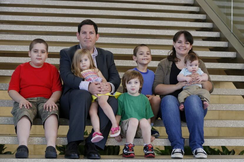 Josh Gravens (second from left, top), a registered sex offender, sits with his family,...