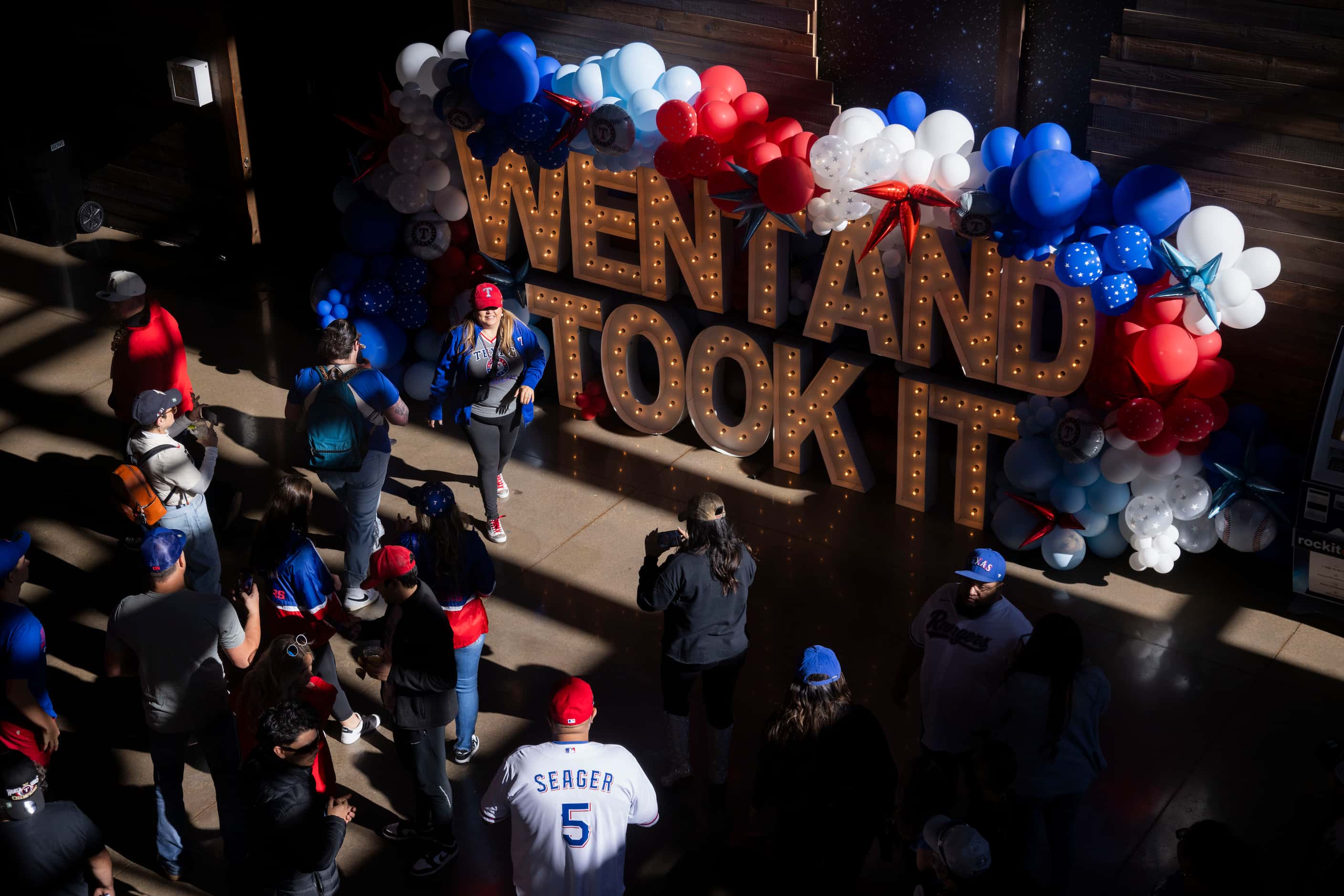 Fans walk by Texas Live!’s “Went and took it” sign in Arlington during the Texas Rangers...