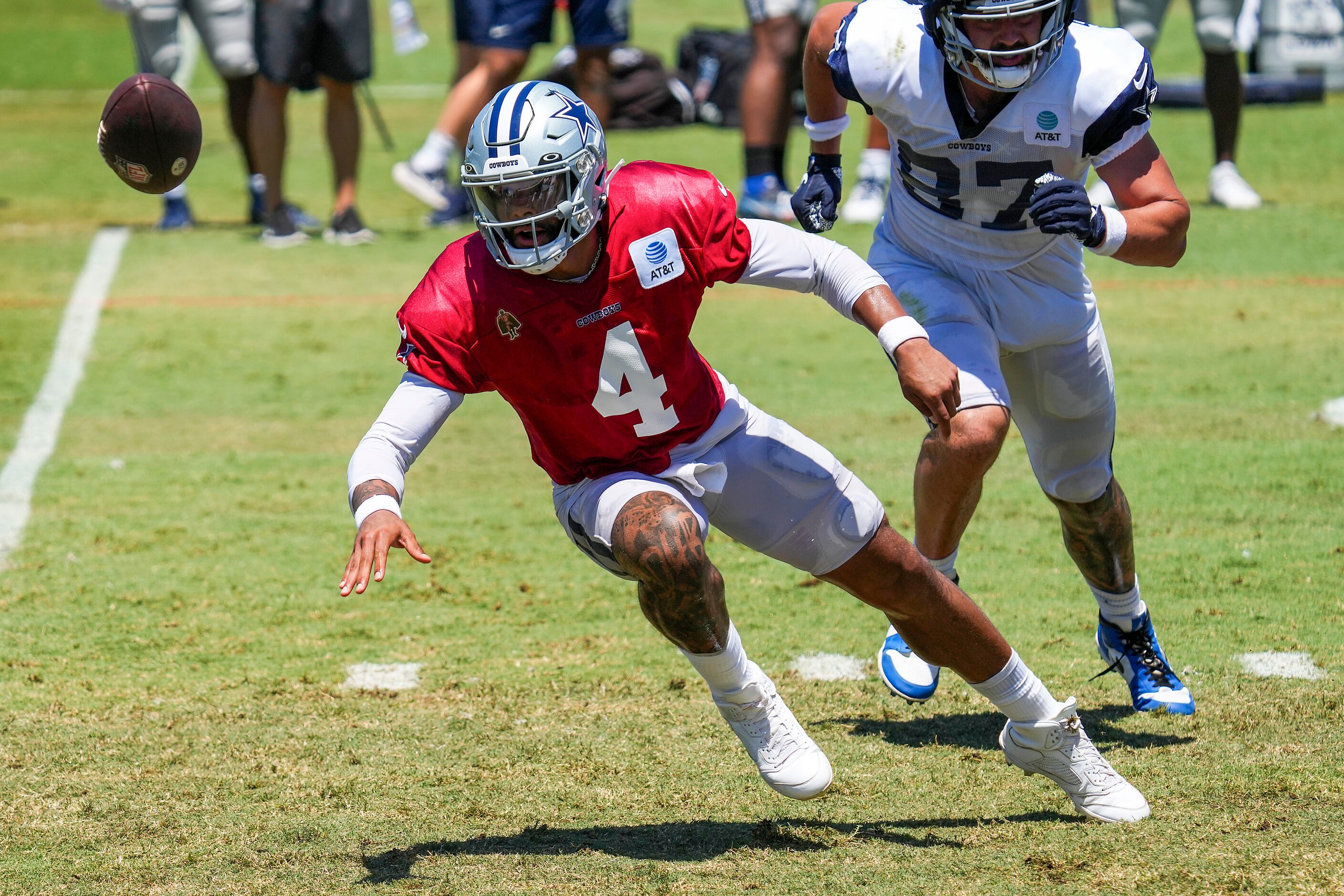 Dallas Cowboys quarterback Dak Prescott (4) pitches the ball while slipping to the turf...