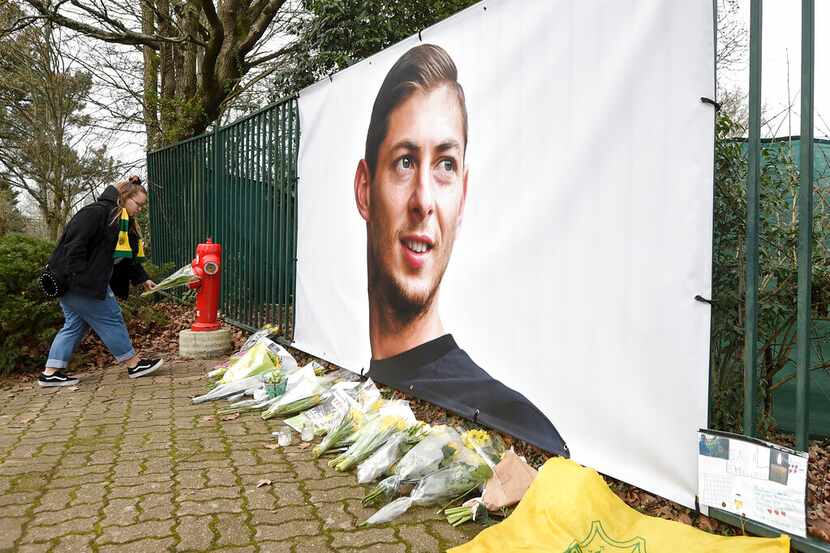 Ramos de flores y otros tributos desplegados cerca de una foto del futbolista argentino...
