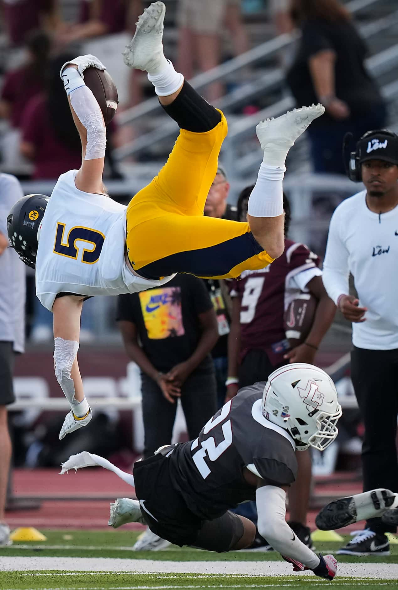 Highland Park running back Jay Cox (5) flies over Lewisville defensive back Jordan Johnson...