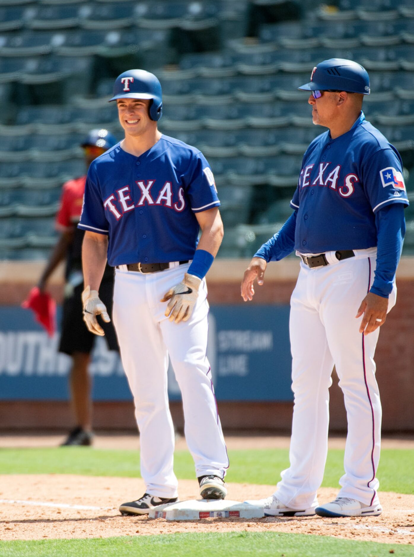 Texas Rangers' Nick Solak is congratulated by first base coach Hector Ortiz after hitting a...