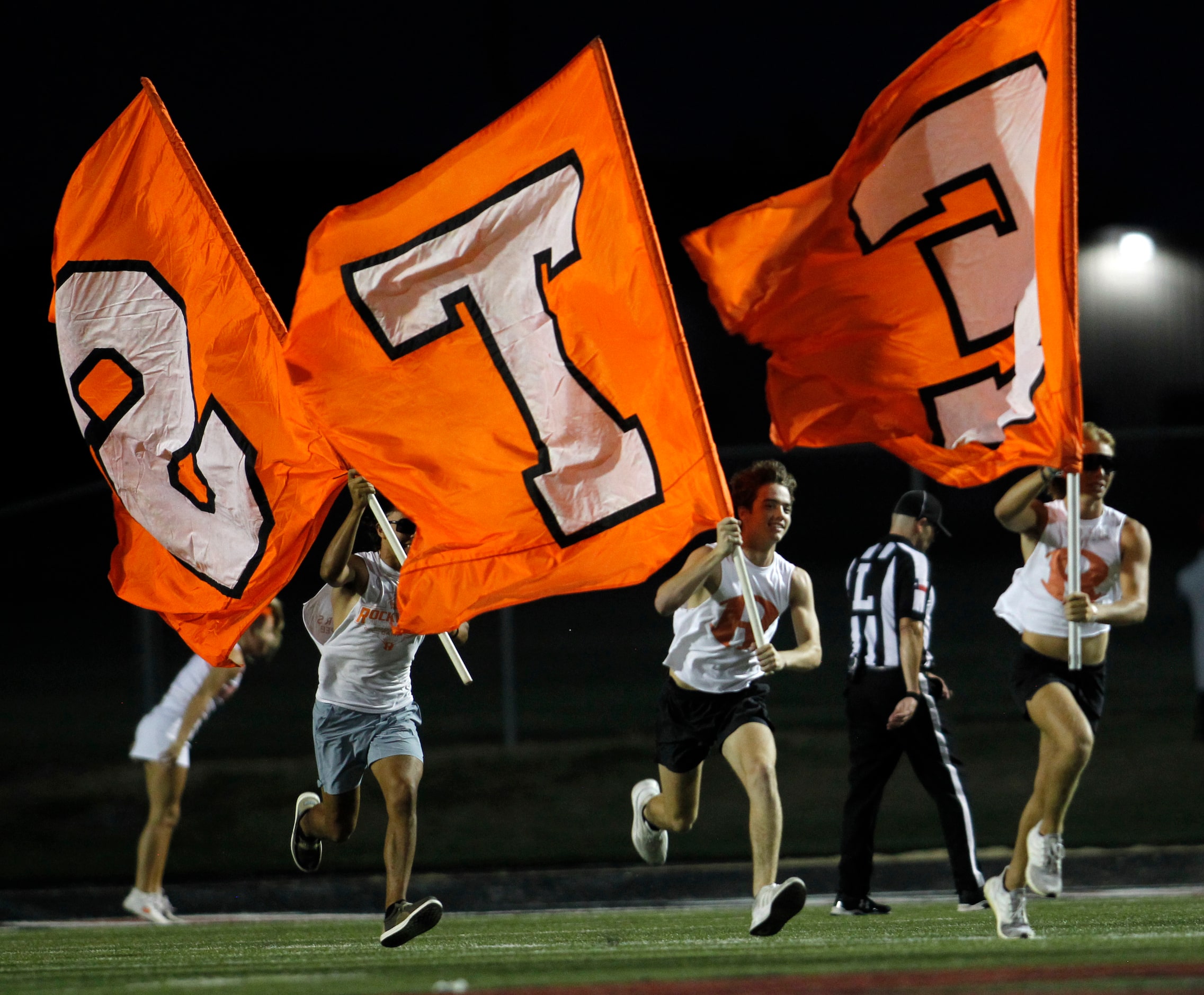 Rockwall flag wavers sprint across the field following a first half yellow-jackets touchdown...