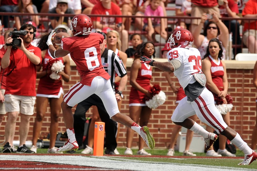 Oklahoma Sooners wide receiver Austin Bennett (8) catches a touchdown pass while being...
