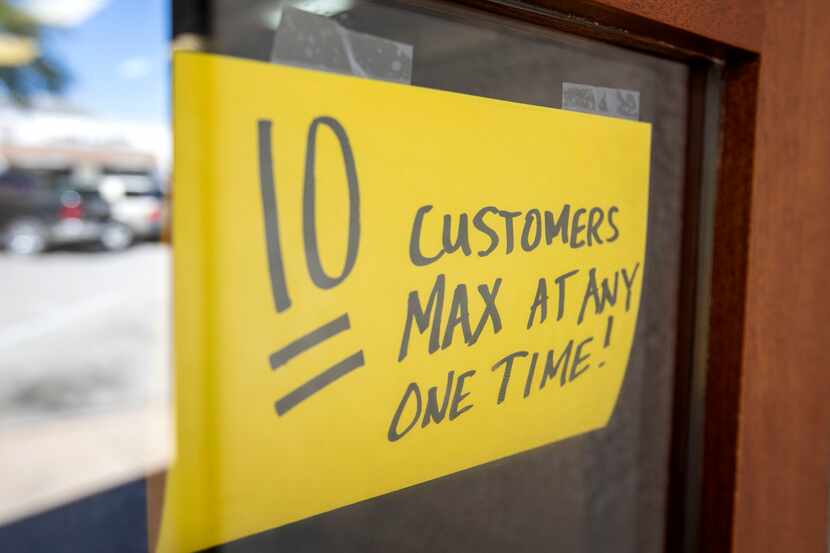 A sign announces that only 10 customers at a time may enter Kuby's Sausage House and...