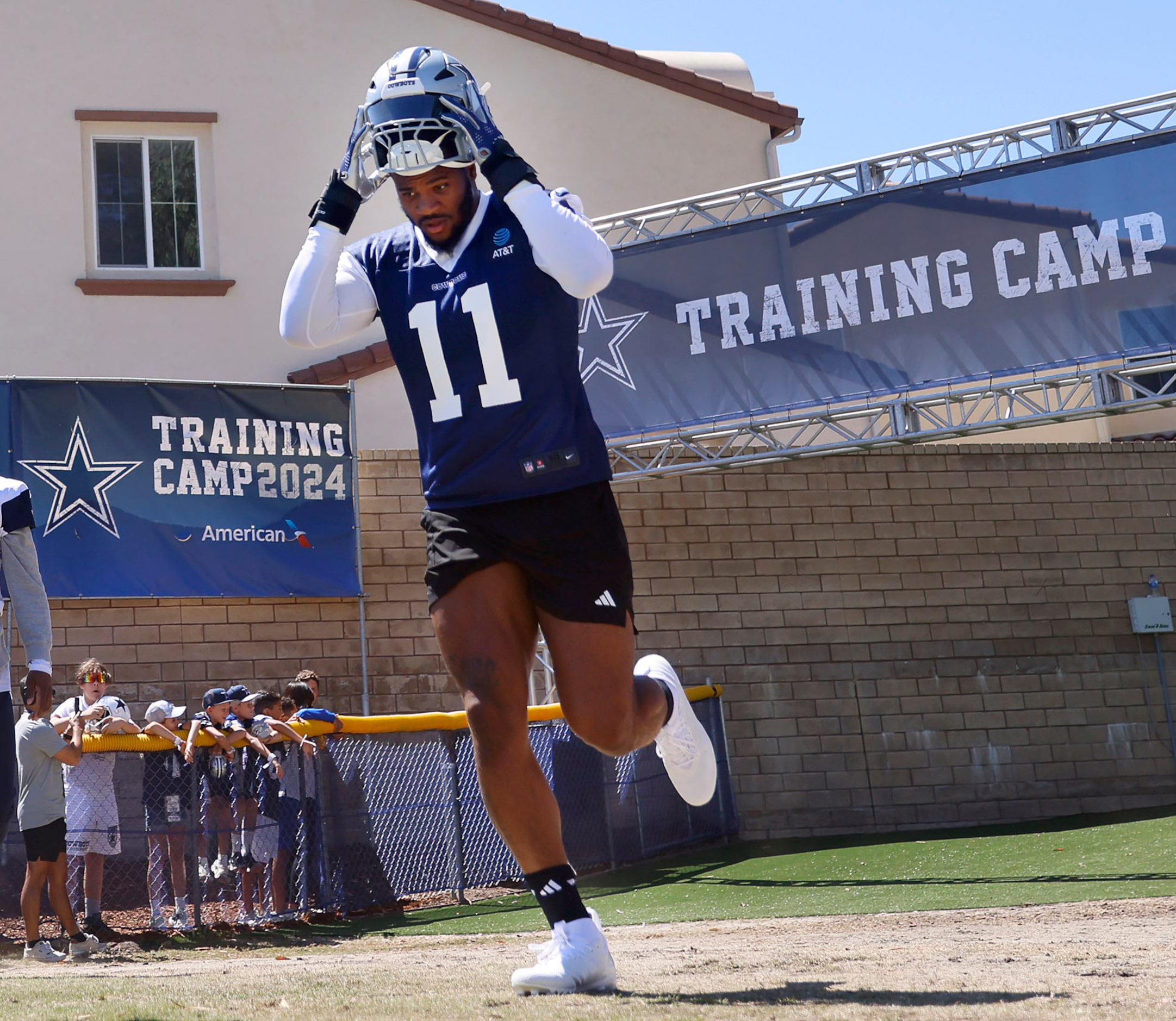 Dallas Cowboys linebacker Micah Parsons (11) jogs onto the field for the start of a training...