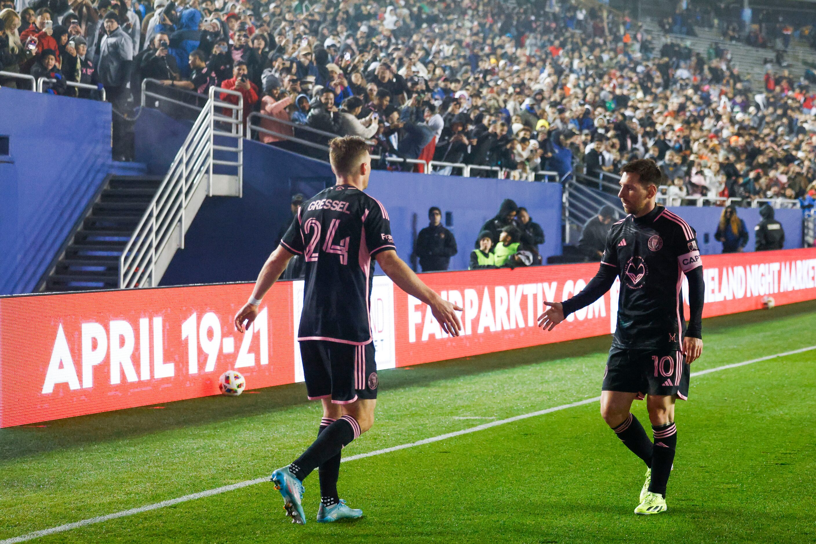 Fans cheer for Inter Miami forward Lionel Messi as he gives a five to Inter Miami defender...