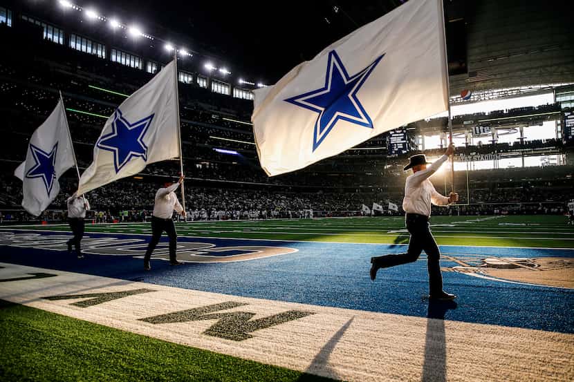 The Dallas Cowboys flag team flies through the end zone following a first half touchdown in...