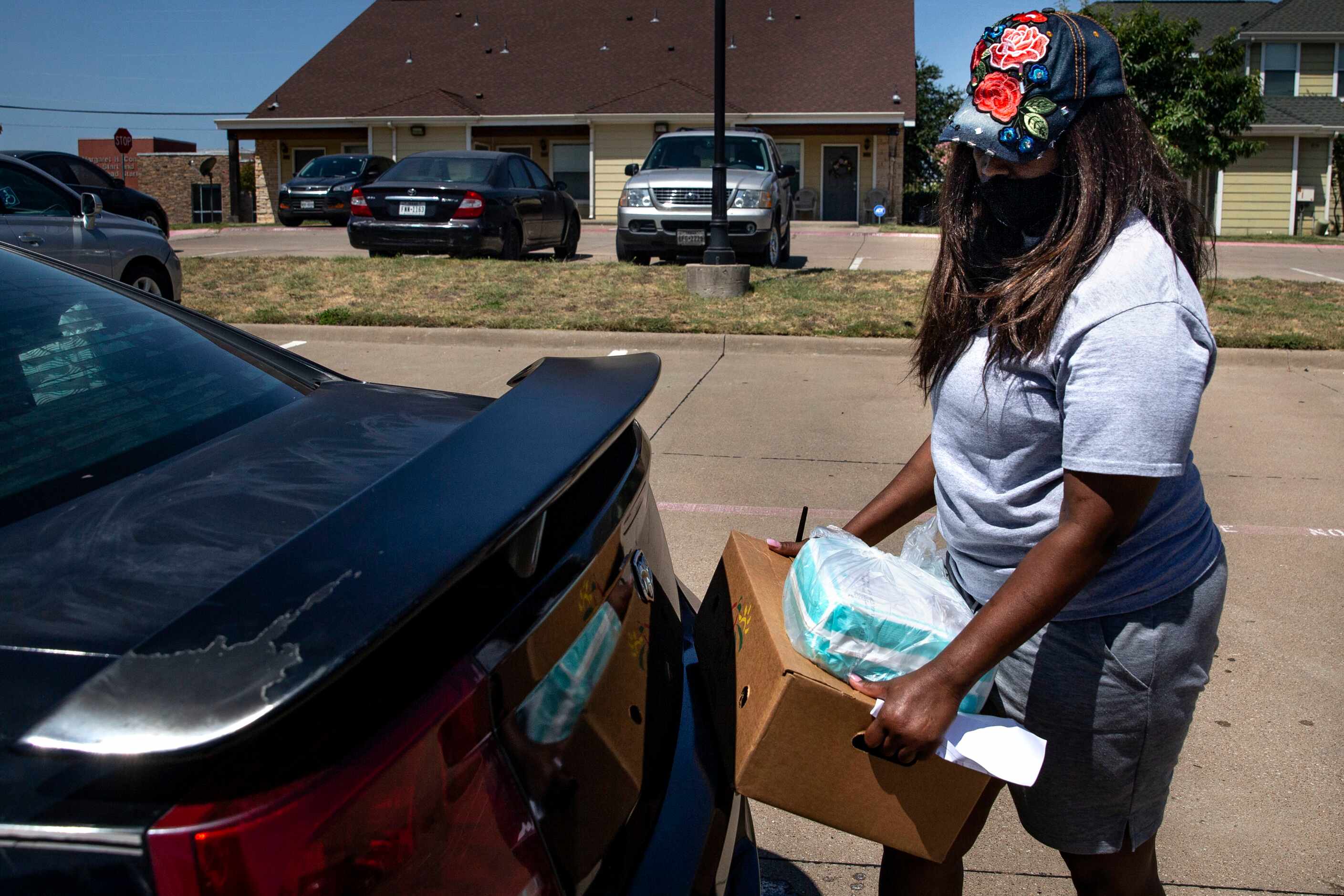 President and founder Alexandrea Crutcher-Horsley places diapers in a family's car trunk...