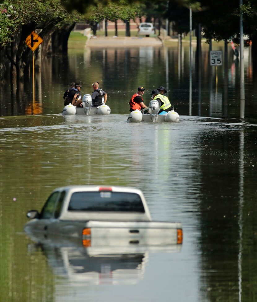 Customs and Border Patrol boats look through a neighborhood which was flooded when the...