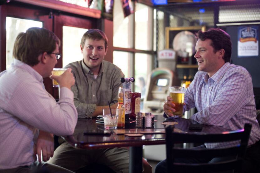 Luke Tyler, left, Brad Brady and Alex Prince enjoy beers during happy hour at The Cellar...