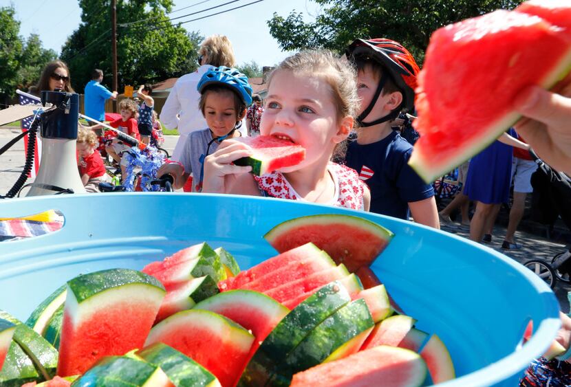 Piper Bartley, 5, samples watermelon during the Sparkman Club Estates July 4th Parade in...