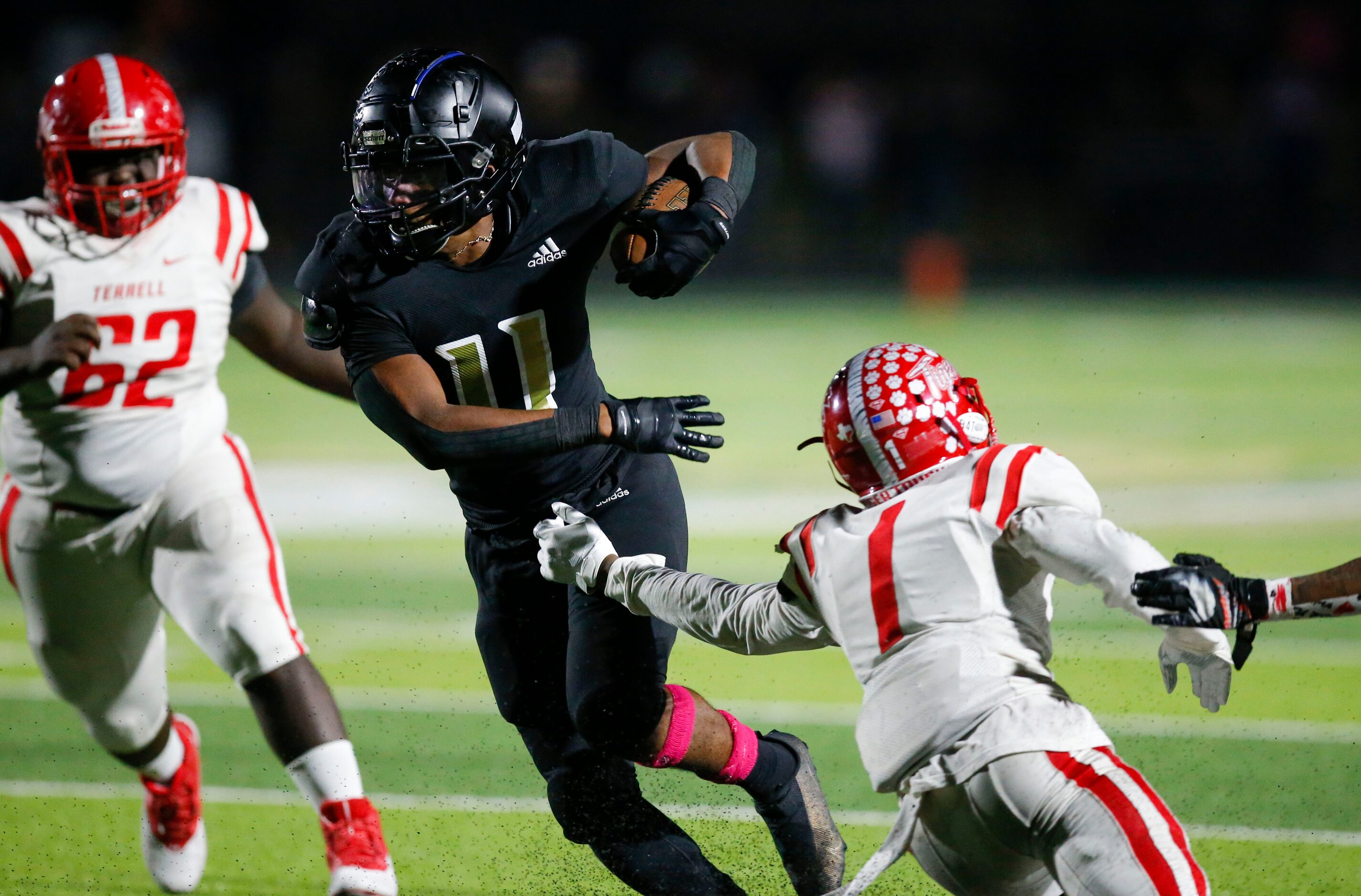 Kaufman junior running back Braxton Garmon (11) slips past Terrell junior Kanye Nix (1)...