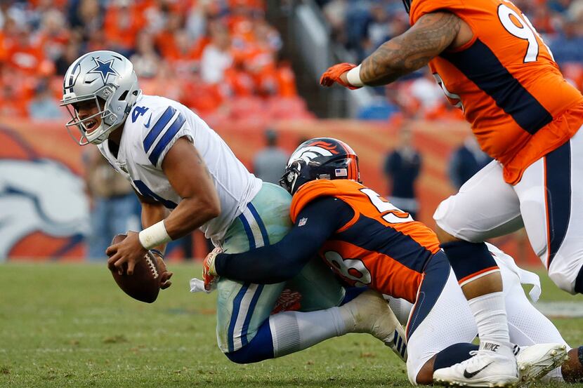 Dallas Cowboys quarterback Dak Prescott (4) is tackled by Denver Broncos outside linebacker...