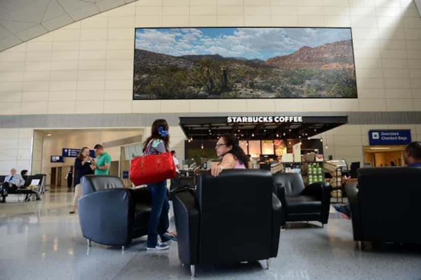 
Artist Dennis Blagg's painting, "Cosmic Big Bend," hangs above a Starbucks at Dallas/Fort...