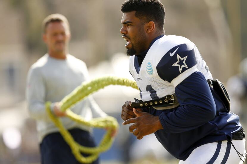 Dallas Cowboys running back Ezekiel Elliott (21) works out with trainer Britt Brown during...