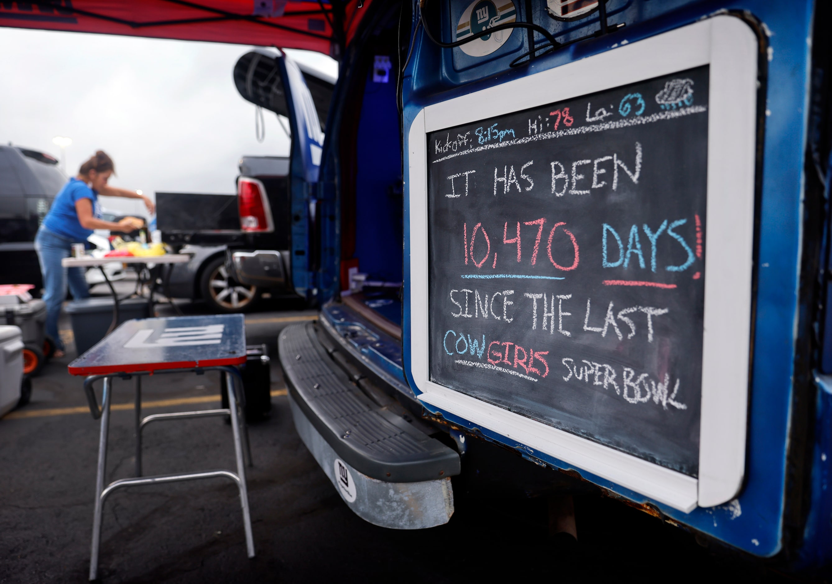 A New York Giants fan tailgating in the parking lot post a chalkboard telling fans the last...