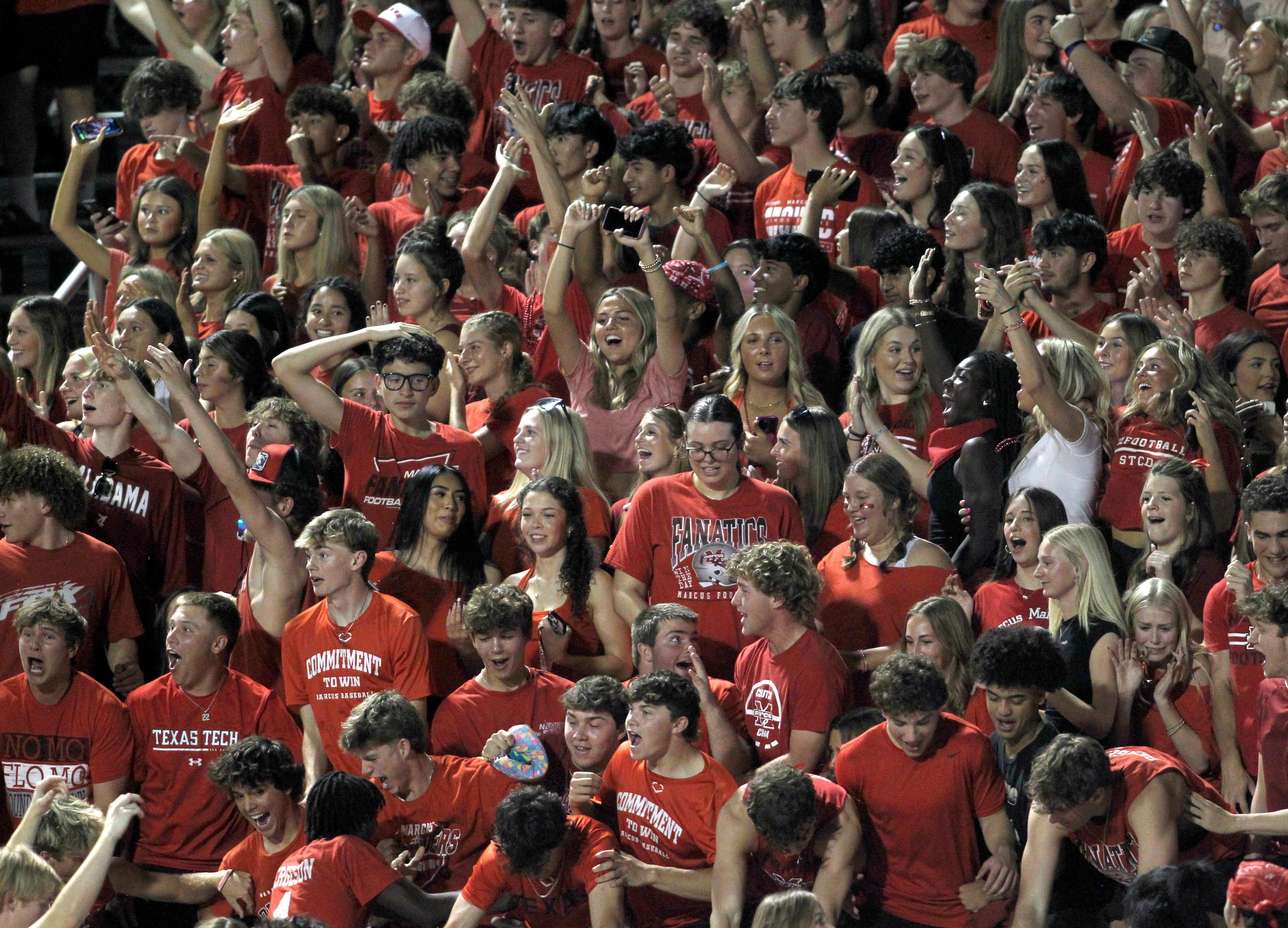 Fans filling the Flower Mound Marcus student section celebrate following a first quarter...