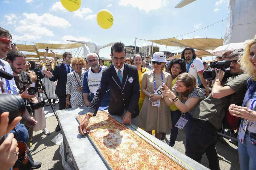 Italy's judge of the "Guinness World Record" Lorenzo Veltri (C) measures the length of the...