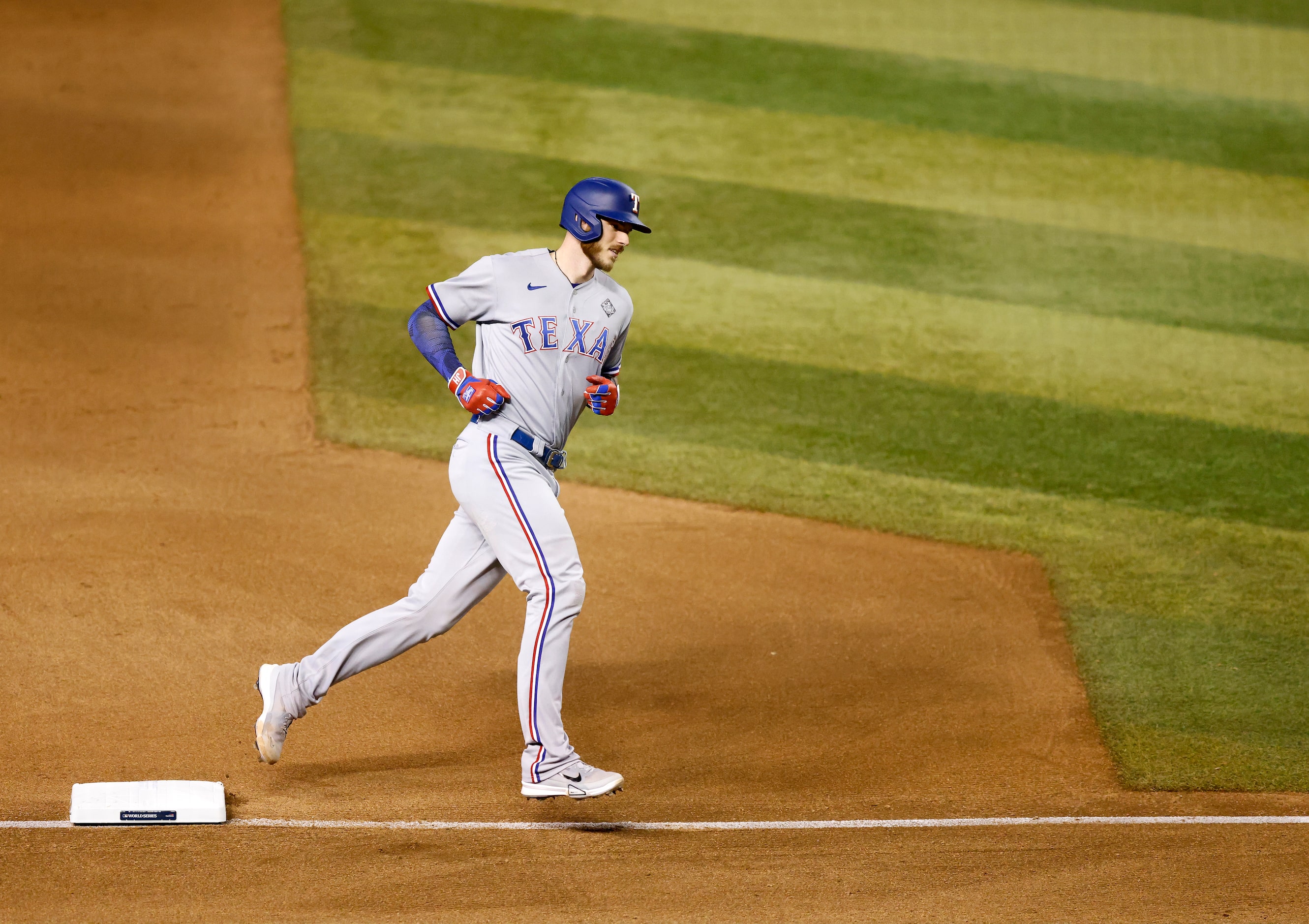 Texas Rangers catcher Jonah Heim rounds third base after hitting a solo home run during the...