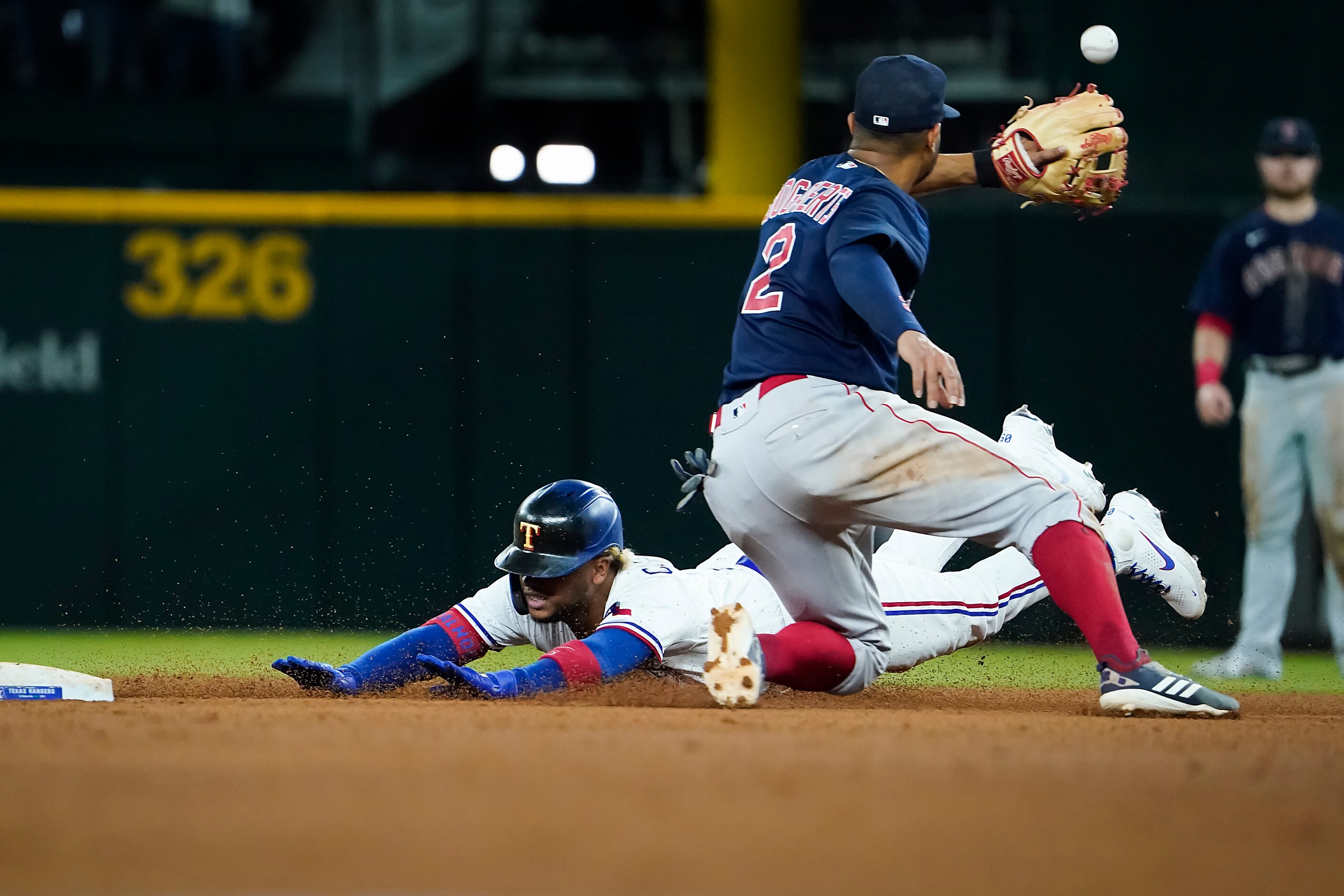 Texas Rangers designated hitter Willie Calhoun slides into second base with a double ahead...