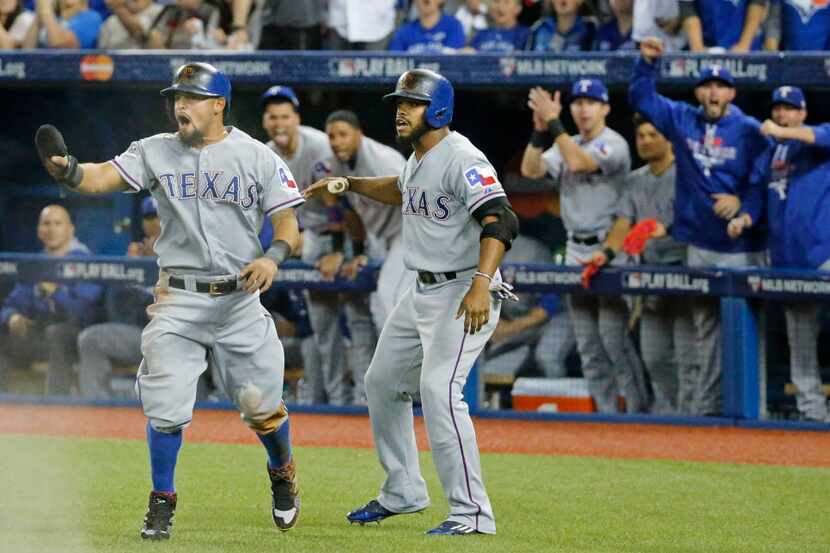 Texas Rangers Rougned Odor (12) and  Delino DeShields (7) react after Odor scored the game's...