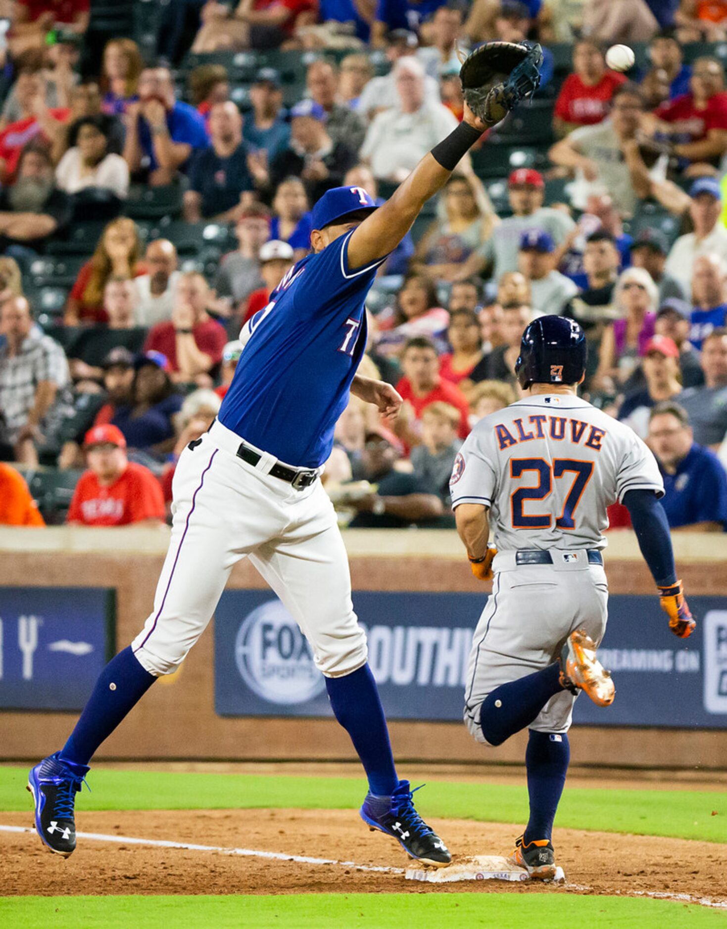 Houston Astros second baseman Jose Altuve (27) is safe at first base with a bunt single as...