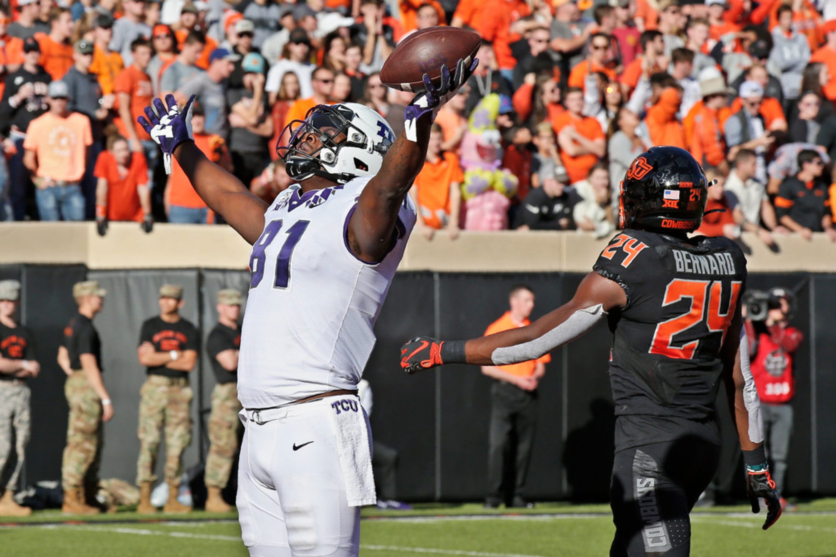 TCU tight end Pro Wells (81) celebrates a touchdown in front of Oklahoma State safety...