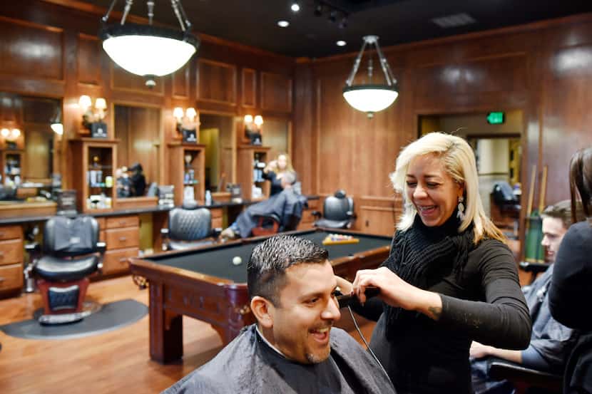 Victor Figueroa, 42, of Dallas, has his hair cut by stylist Rita Williams at the Boardroom...