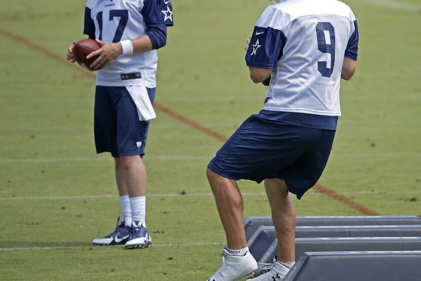 Dallas Cowboys quarterback Tony Romo (9) practices as quarterback Kellen Moore looks on...