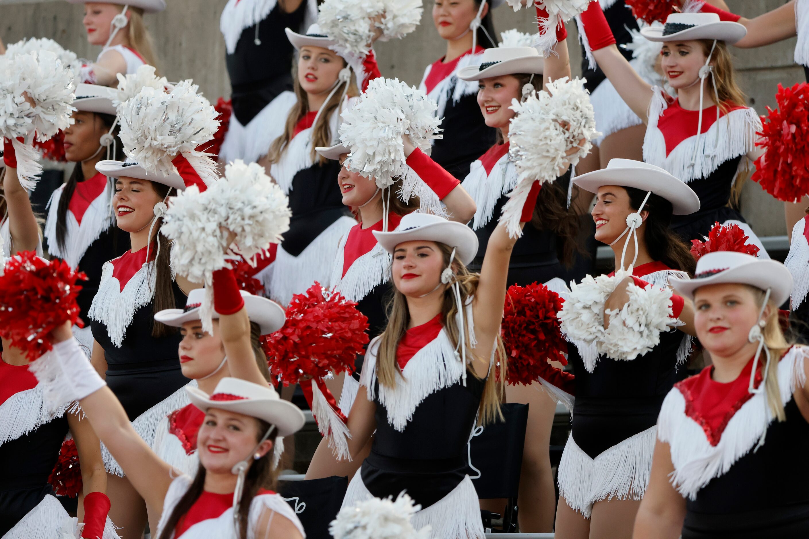 The Coppell Lariettes drill team performs during a high school football game against...