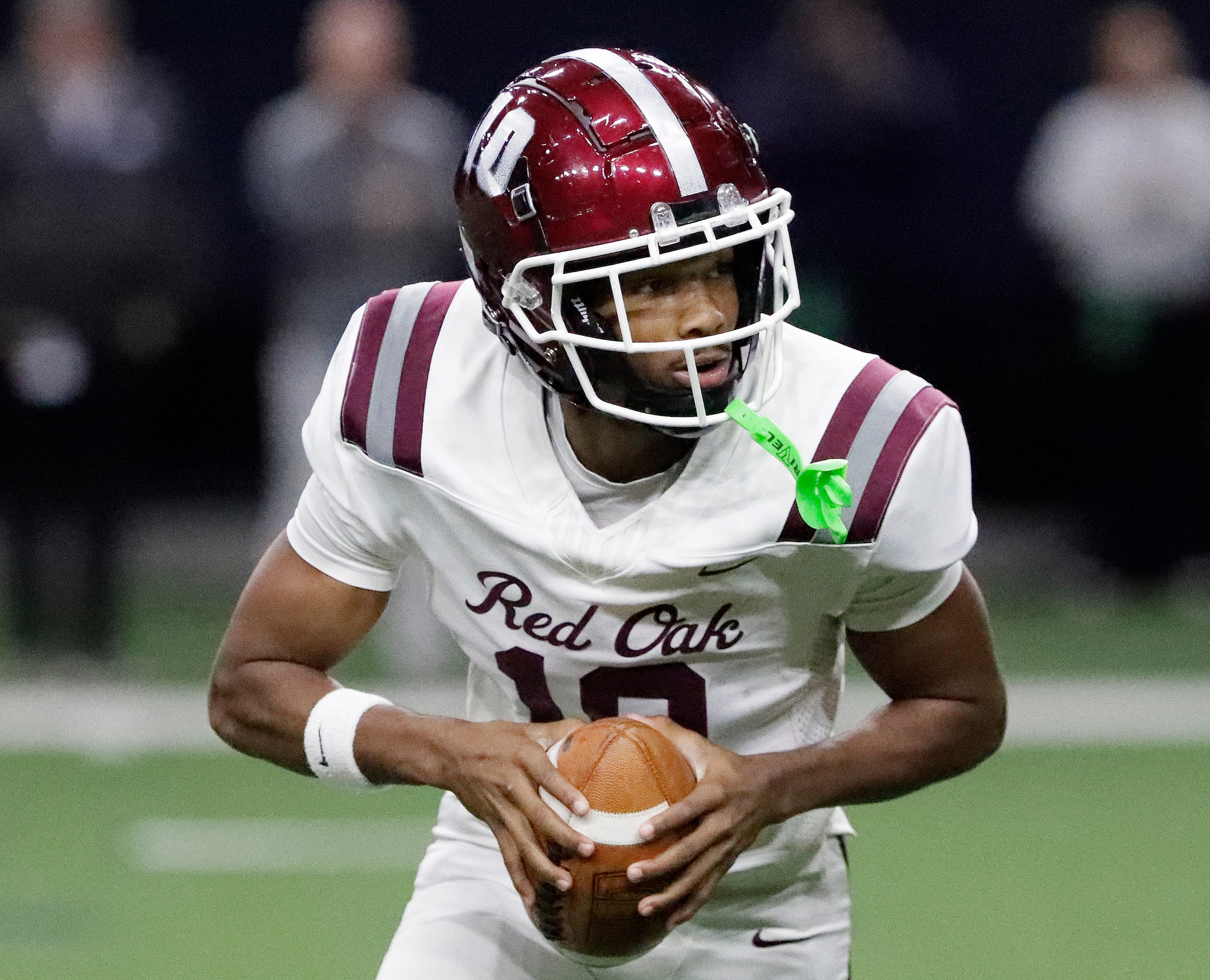 Red Oak High School quarterback Billy Middleton (10) rolls out to pass during the first half...