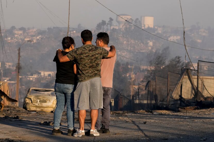 Residentes miran las casas quemadas y los escombros que dejó un incendio forestal que...