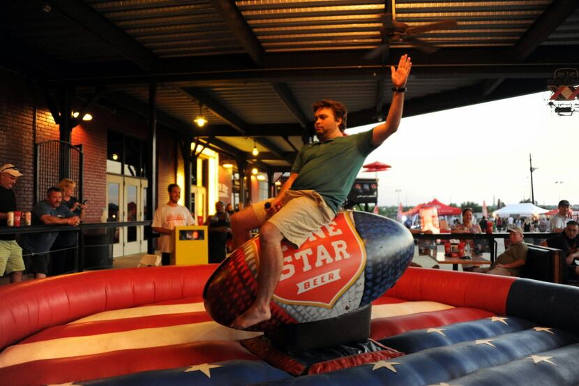 Travis Hughes rides the mechanical armadillo at Lone Star Beer Texas Heritage Festival at...